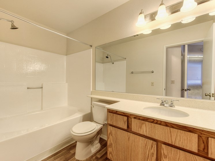 Vacant apartment home bathroom with sink and vanity and tub/shower combination.
